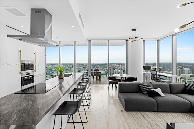 living room with a wall of windows, sink, and light tile patterned floors