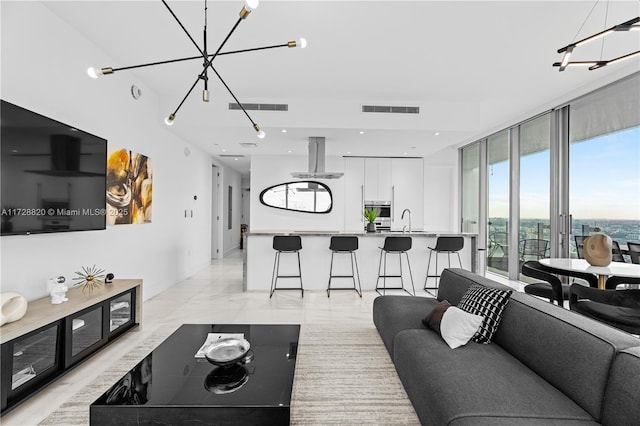 living room featuring sink, a notable chandelier, and expansive windows