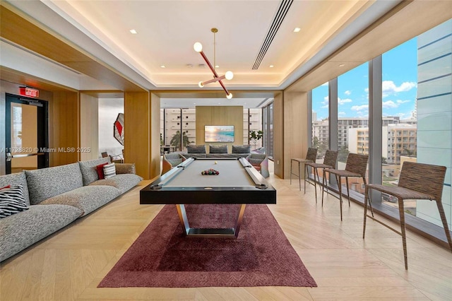 playroom with expansive windows, a raised ceiling, and billiards