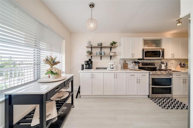 kitchen with pendant lighting, white cabinetry, stainless steel appliances, and decorative backsplash