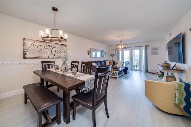 dining area featuring french doors, a chandelier, and hardwood / wood-style floors