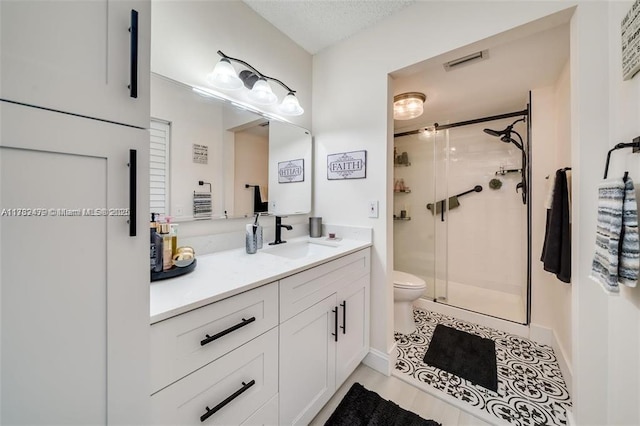 bathroom with tile patterned flooring, vanity, toilet, and a shower with shower door