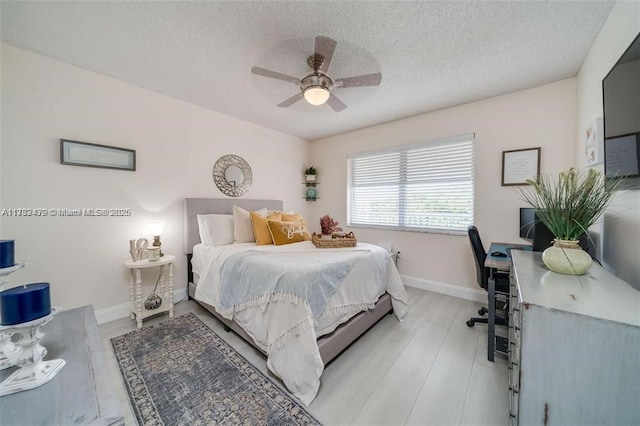 bedroom with ceiling fan and a textured ceiling