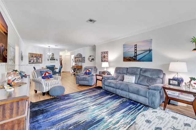 living room featuring ornamental molding, hardwood / wood-style floors, and a notable chandelier