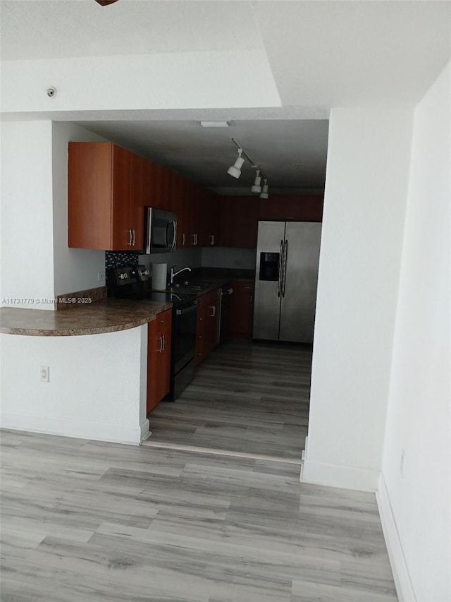 kitchen featuring track lighting, stainless steel appliances, sink, and decorative backsplash