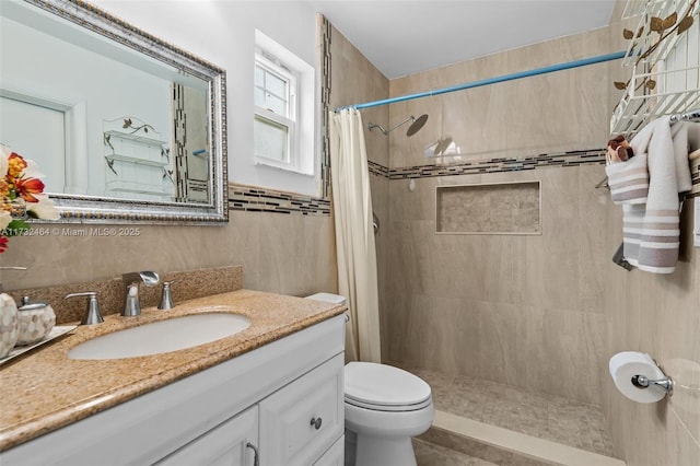 bathroom featuring vanity, toilet, tile walls, and a shower with shower curtain