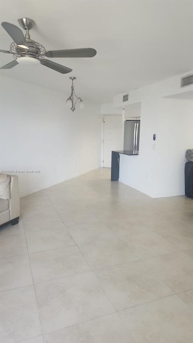 empty room featuring ceiling fan and light tile patterned flooring