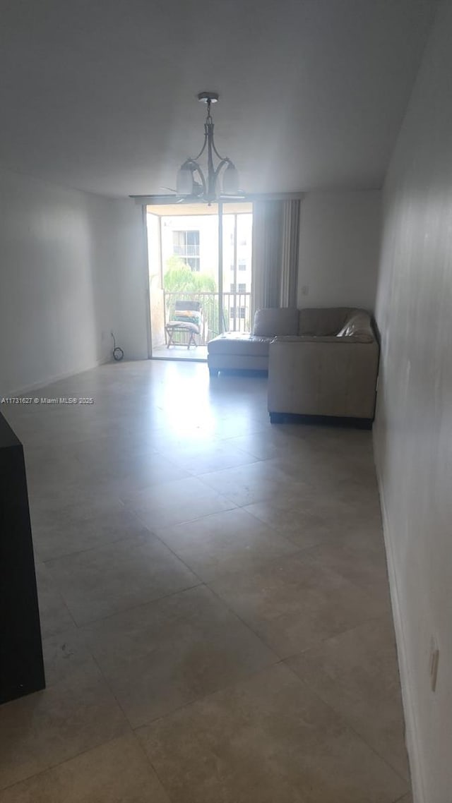 unfurnished living room featuring a chandelier