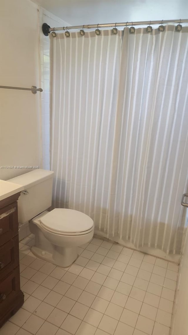 bathroom featuring vanity, toilet, and tile patterned flooring