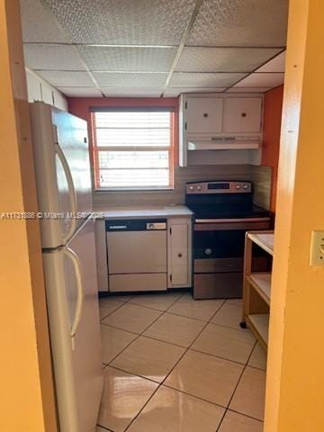 kitchen with white cabinetry, light tile patterned floors, white appliances, and a paneled ceiling