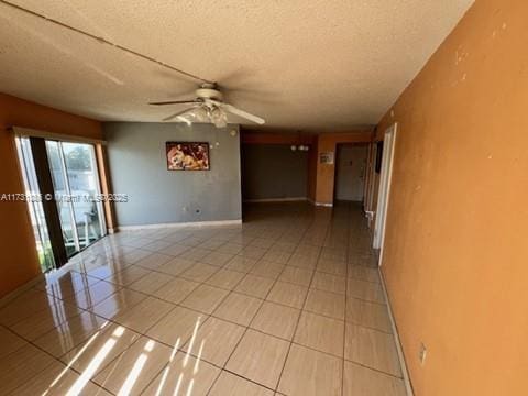 empty room with ceiling fan and a textured ceiling