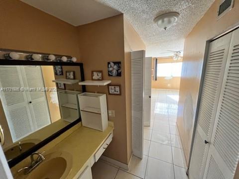 bathroom featuring vanity, tile patterned flooring, and a textured ceiling