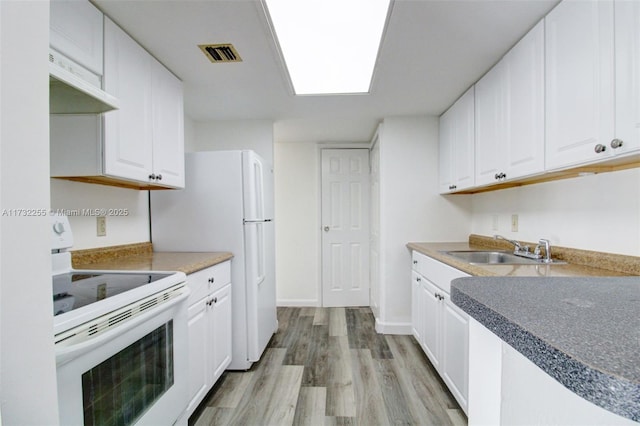 kitchen with a sink, visible vents, white appliances, under cabinet range hood, and light wood-style floors