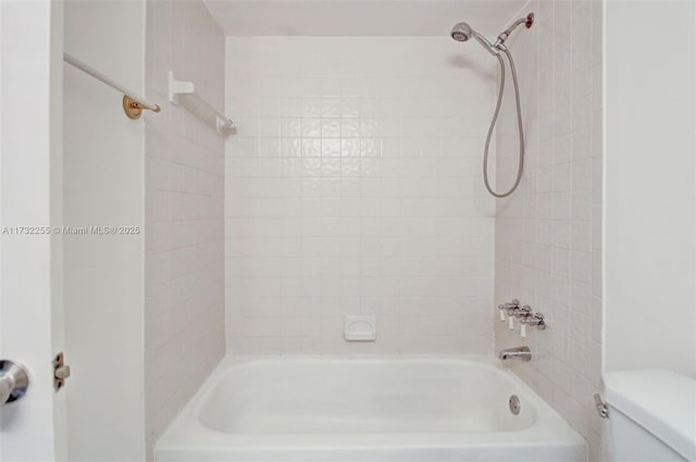 bathroom featuring bathtub / shower combination and toilet