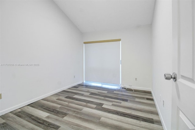 spare room with lofted ceiling and hardwood / wood-style floors