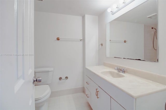 bathroom with baseboards, vanity, and toilet