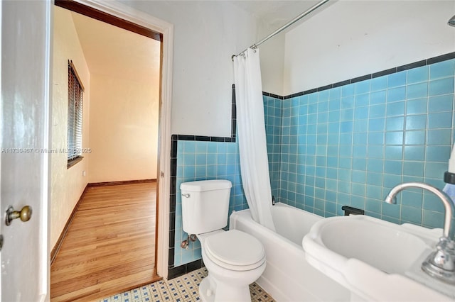 full bathroom with tile patterned floors, toilet, sink, tile walls, and shower / bath combination with curtain