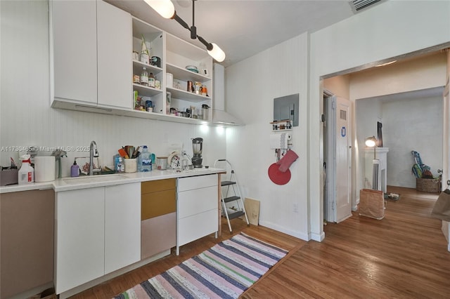 kitchen featuring sink, white cabinets, dark hardwood / wood-style floors, and built in shelves