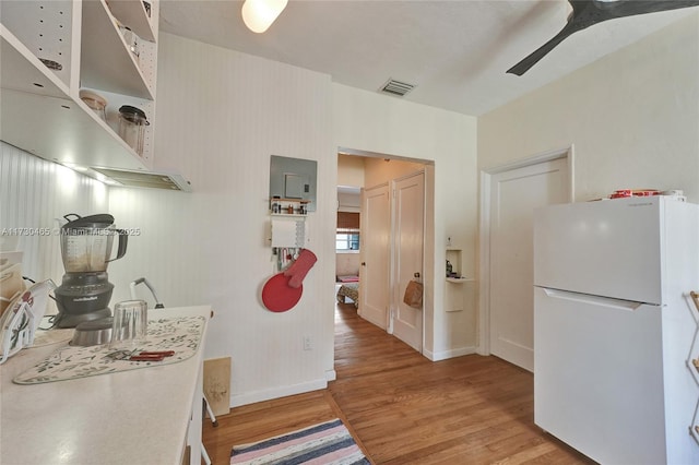 kitchen with ceiling fan, hardwood / wood-style floors, and white fridge