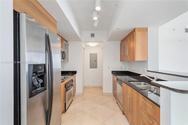 kitchen featuring sink, dark stone counters, light tile patterned floors, electric panel, and stainless steel appliances