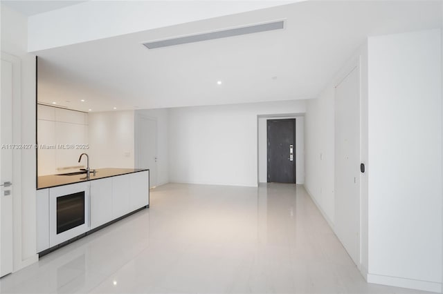 kitchen with recessed lighting, white cabinets, a sink, and modern cabinets