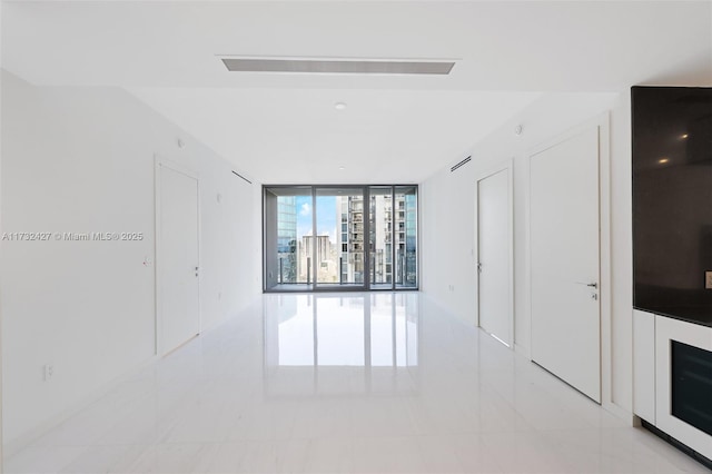 empty room with visible vents and floor to ceiling windows