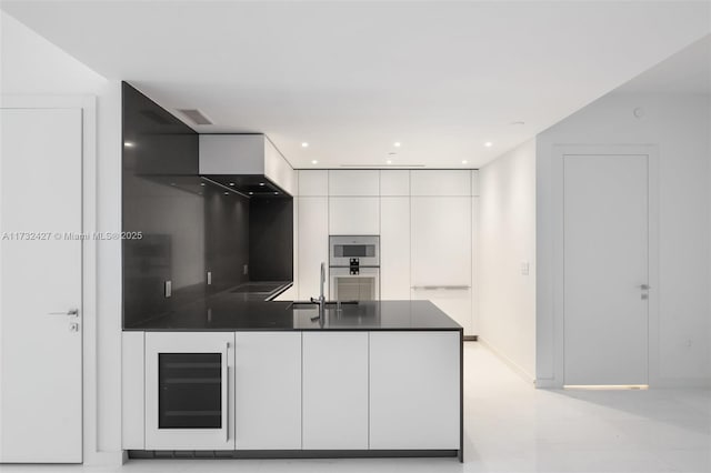 kitchen with visible vents, dark countertops, modern cabinets, white cabinetry, and a sink