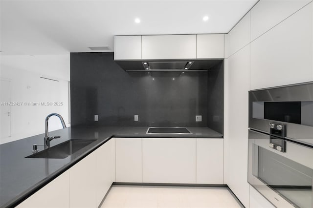 kitchen featuring decorative backsplash, modern cabinets, black electric stovetop, white cabinetry, and a sink