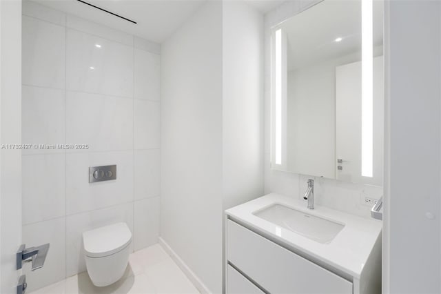 bathroom with tile walls, vanity, and toilet