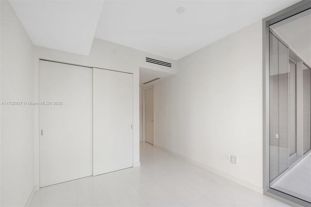 unfurnished bedroom featuring a closet, visible vents, and baseboards