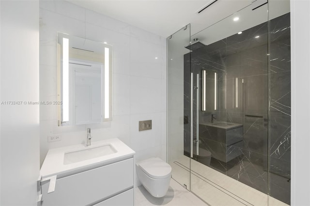 bathroom with a shower stall, vanity, toilet, and tile walls