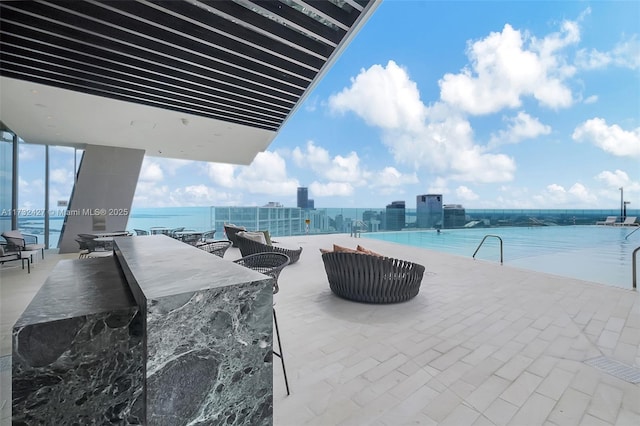 view of patio / terrace with a city view, a water view, and outdoor dry bar