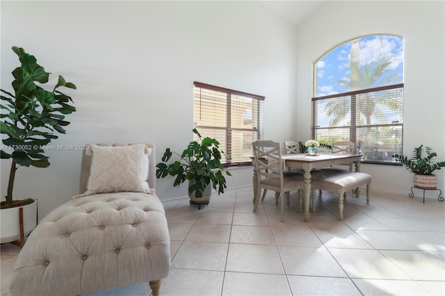 dining space with light tile patterned floors and high vaulted ceiling