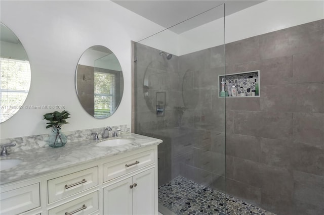 bathroom with vanity and tiled shower