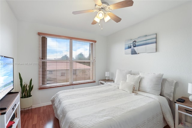 bedroom with dark hardwood / wood-style floors and ceiling fan