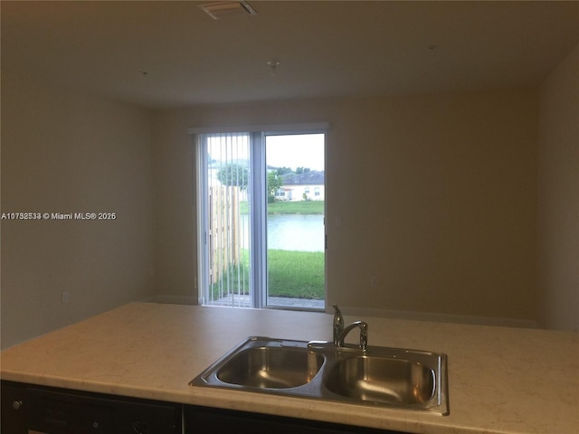 kitchen with a water view, dishwasher, and sink