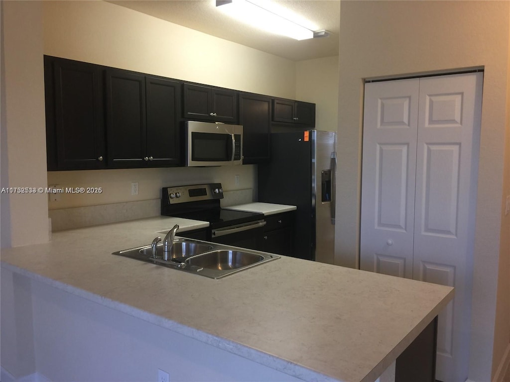 kitchen featuring appliances with stainless steel finishes, sink, and kitchen peninsula