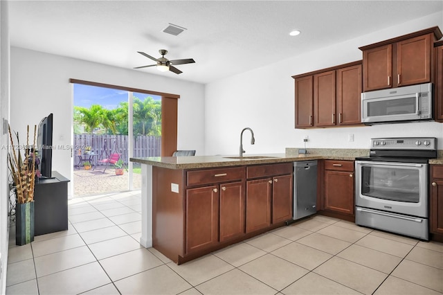 kitchen with sink, ceiling fan, stainless steel appliances, light tile patterned flooring, and kitchen peninsula