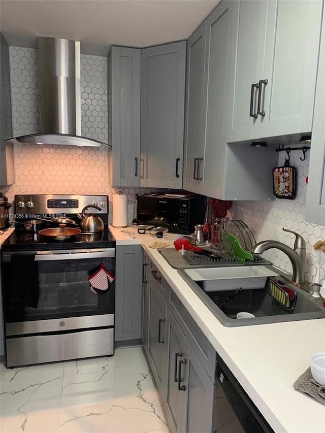 kitchen with wall chimney exhaust hood, sink, gray cabinetry, decorative backsplash, and black appliances