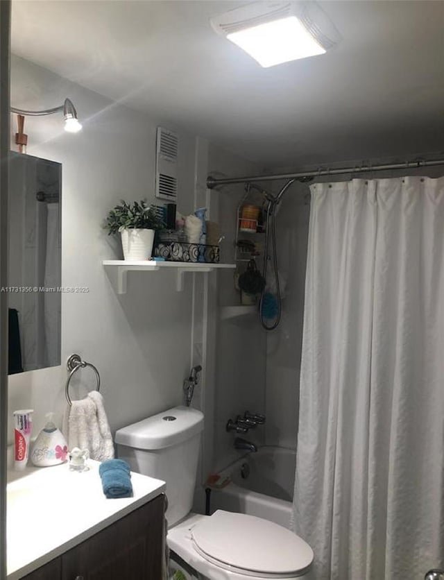 full bathroom featuring vanity, shower / bath combo with shower curtain, and toilet