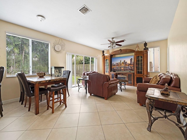 tiled living room with plenty of natural light and ceiling fan