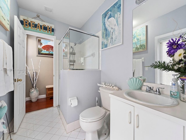 bathroom with vanity, toilet, a shower with shower door, and tile patterned flooring