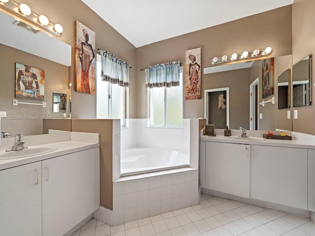 bathroom with vanity, tile patterned flooring, and tiled tub