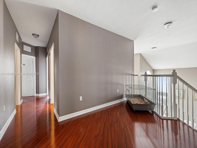 hall featuring lofted ceiling and dark hardwood / wood-style floors