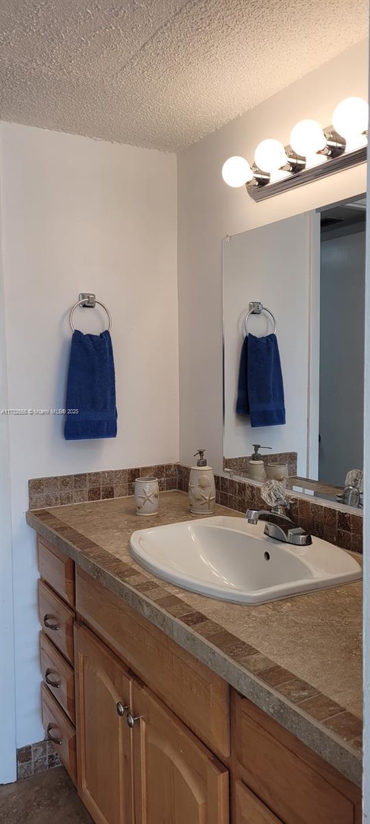 bathroom with vanity and a textured ceiling