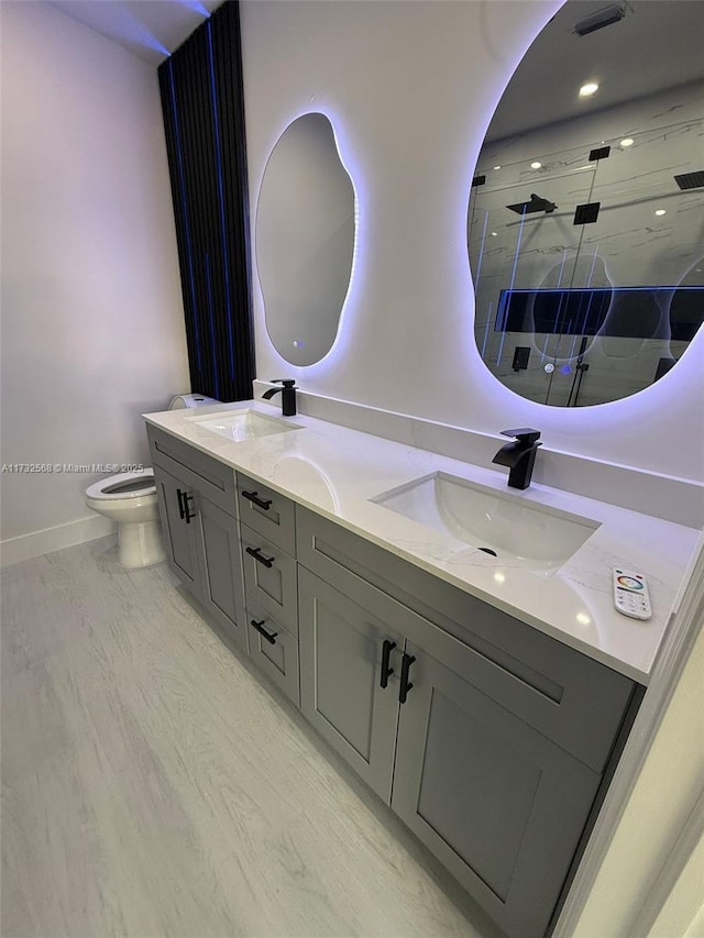 bathroom with vanity, hardwood / wood-style floors, toilet, and walk in shower