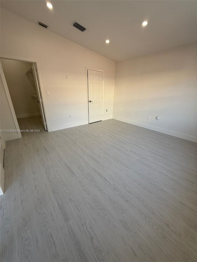 spare room with hardwood / wood-style flooring and lofted ceiling