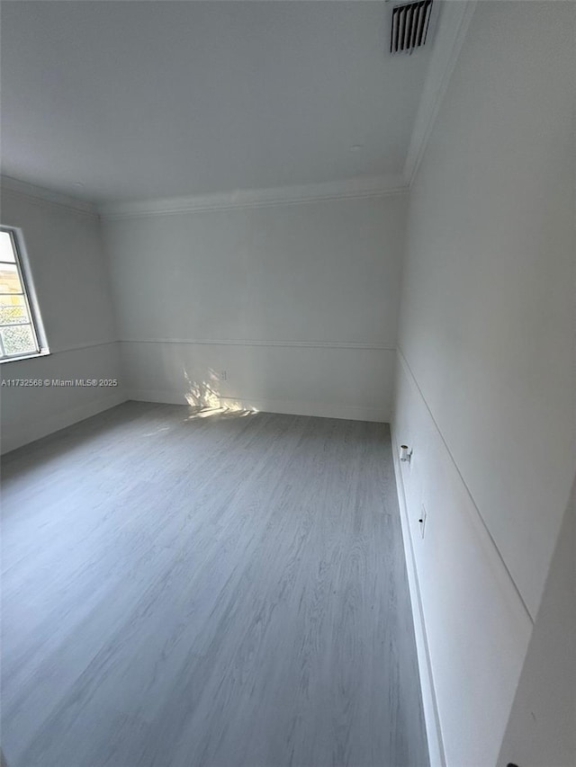 unfurnished room with wood-type flooring and ornamental molding