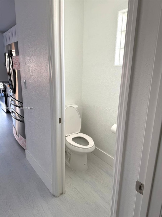 bathroom featuring hardwood / wood-style floors and toilet