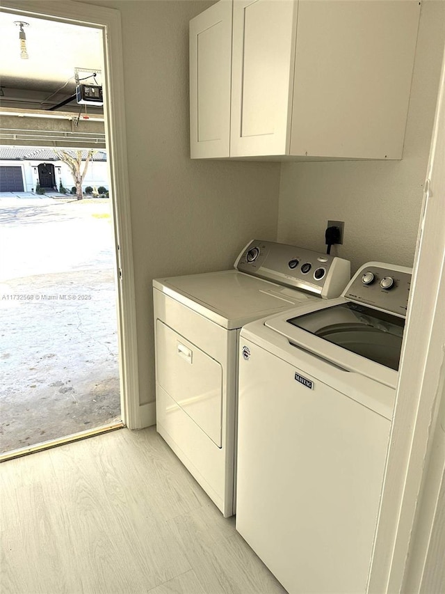 washroom featuring cabinets and washing machine and clothes dryer